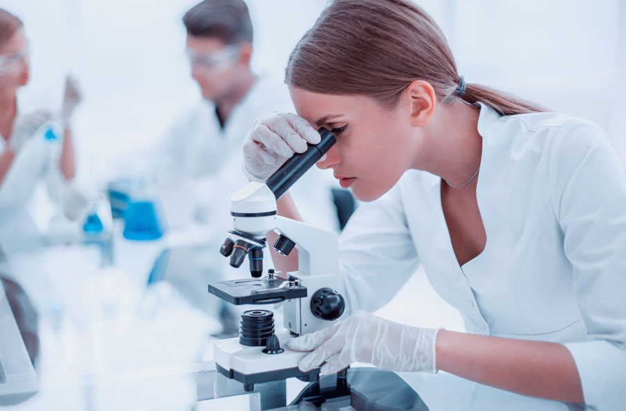 Woman in laboratory at microscope 