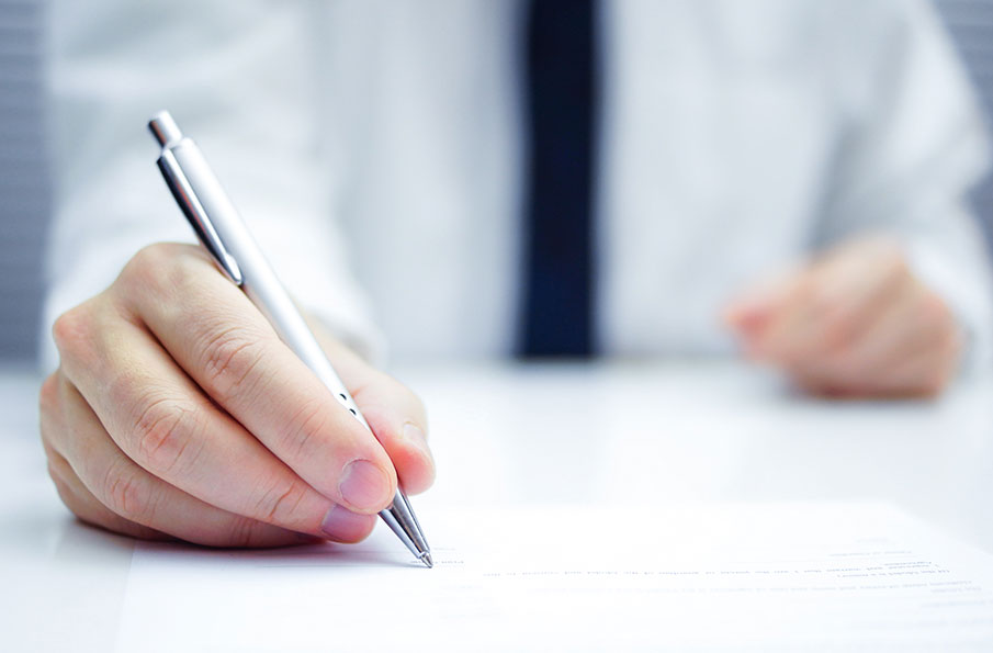 Close up of hand signing contract