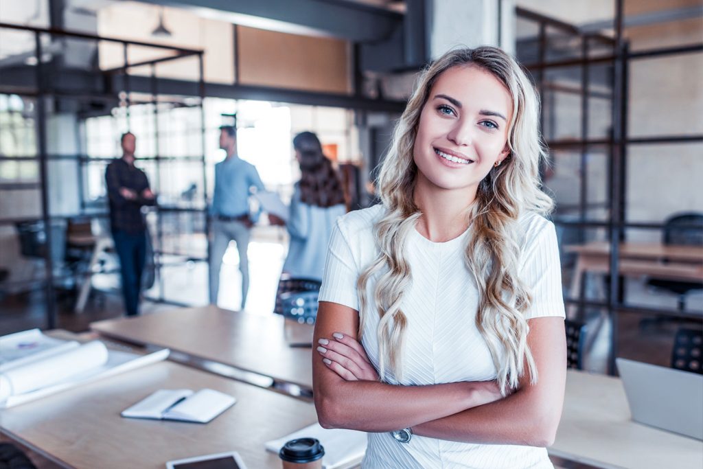 Junge Frau im Büro lächelt freundlich